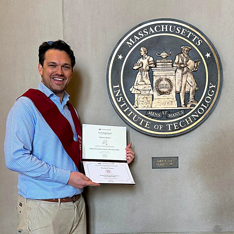 Vladimir K. at MIT, holding his Chief Digital Officer certificates beside the institute seal
